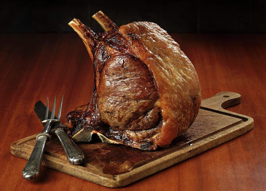 Roast Rack Of Beef On A Chopping Board Photograph by Stuart Macgregor