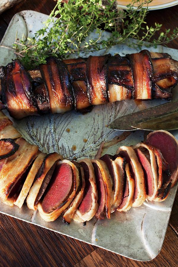 Roast Venison Wrapped In Bacon On A Silver Tray seen From Above Photograph by Katharine Pollak