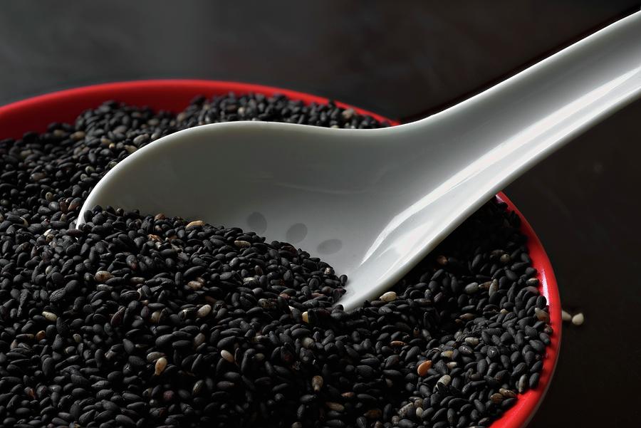 Roasted Black Sesame Seeds With A Porcelain Spoon In A Bowl Photograph by Dr. Martin Baumgrtner
