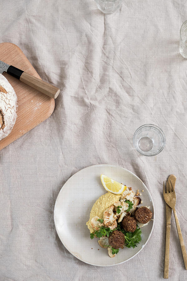 Roasted Cauliflowers, Hummus And Fallafel With Parsley On A Plate At A Table With A Linen Cloth Photograph by Lucie Beck