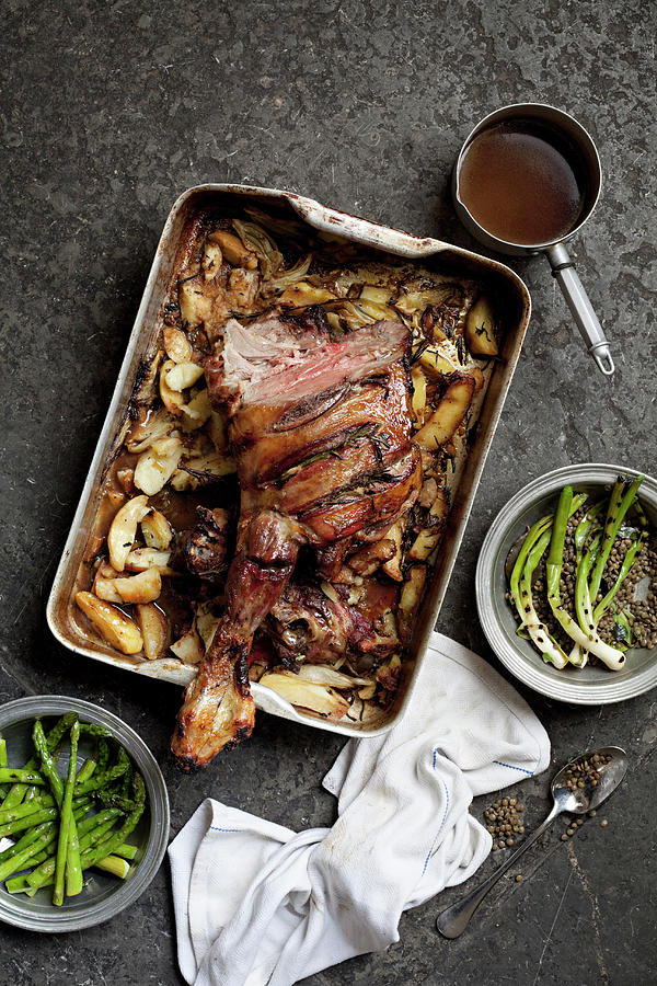 Roasted Leg Of Lamb In A Baking Tray On The Table Along With Gravy And Other Vegetable Dishes Photograph by Steven Joyce