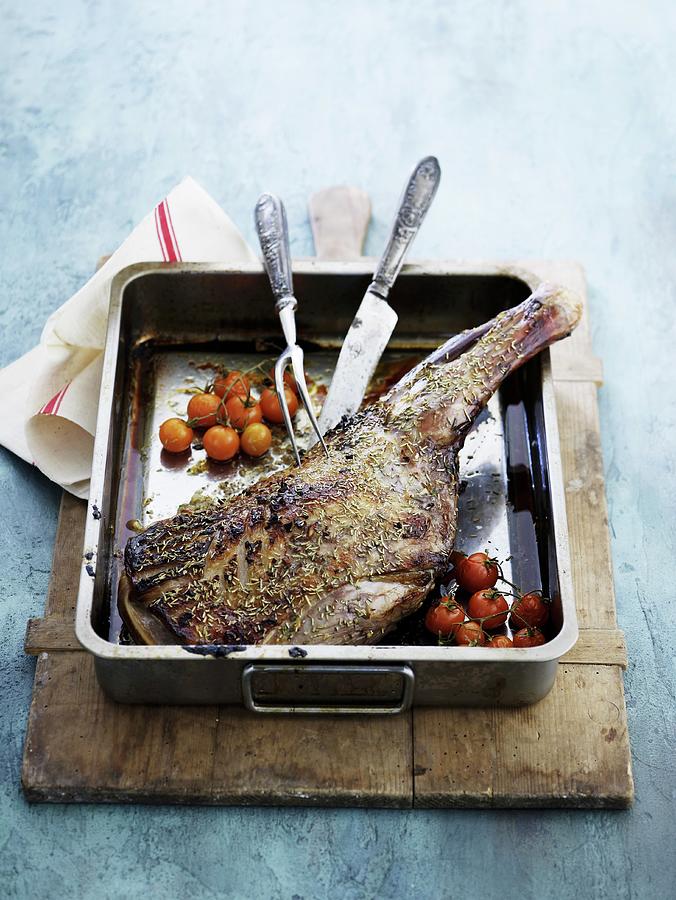 Roasted Leg Of Lamb With Cherry Tomatoes Photograph by Mikkel Adsbl