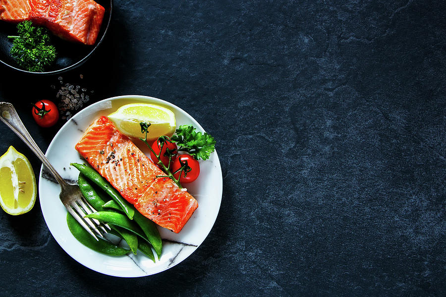 Roasted Salmon With Poached Green Peas, Tomatoes, Lemon In Plate And Salmon Fillet In Vintage Frying Pan Photograph by Yuliya Gontar
