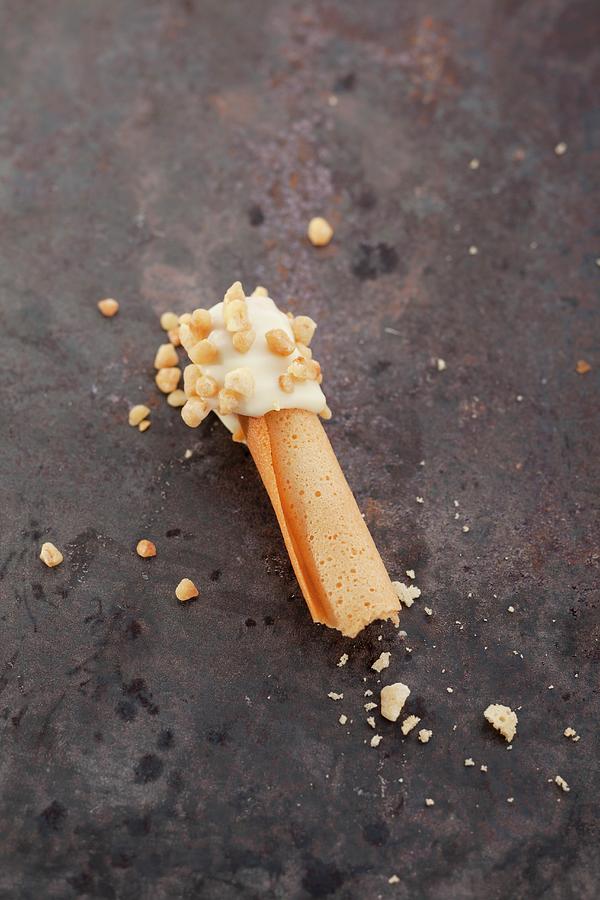 Rolled Wafers Dipped In White Chocolate And Chopped Nuts Photograph by Eising Studio - Food Photo & Video