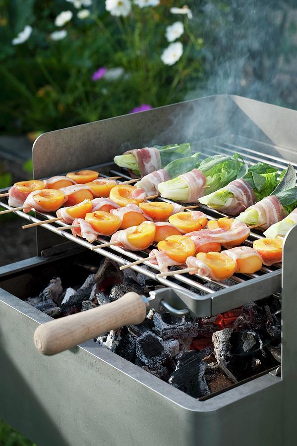 Romaine Lettuce And Apricots Wrapped In Bacon On The Barbecue Photograph by Gerlach, Hans