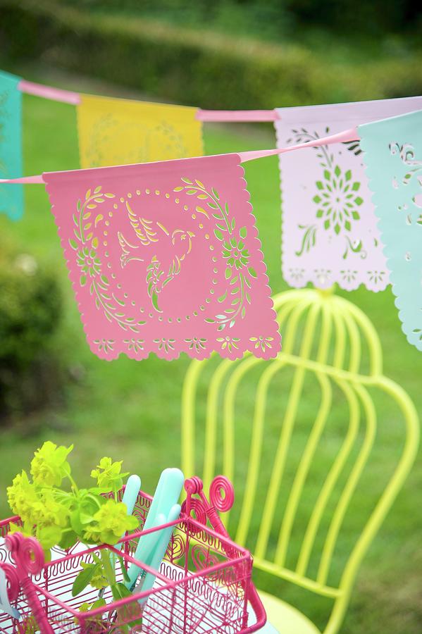 Romantic Bunting With Perforated Bird Motifs Above Pink Cutlery Basket In Garden Photograph by Winfried Heinze