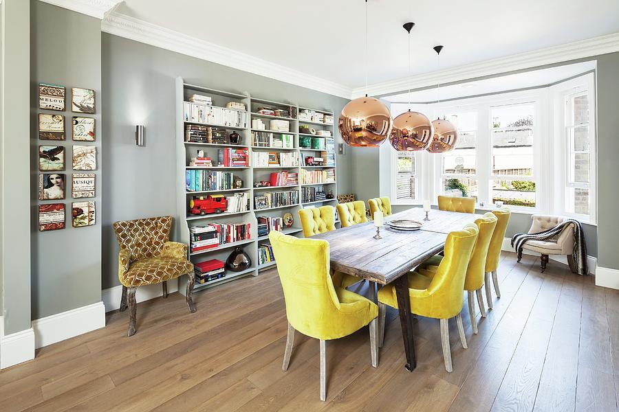 Room With Bay Window In English House; Long Table, Yellow Upholstered Chairs, Board Floor And Grey Bookcases Photograph by Simon Maxwell Photography