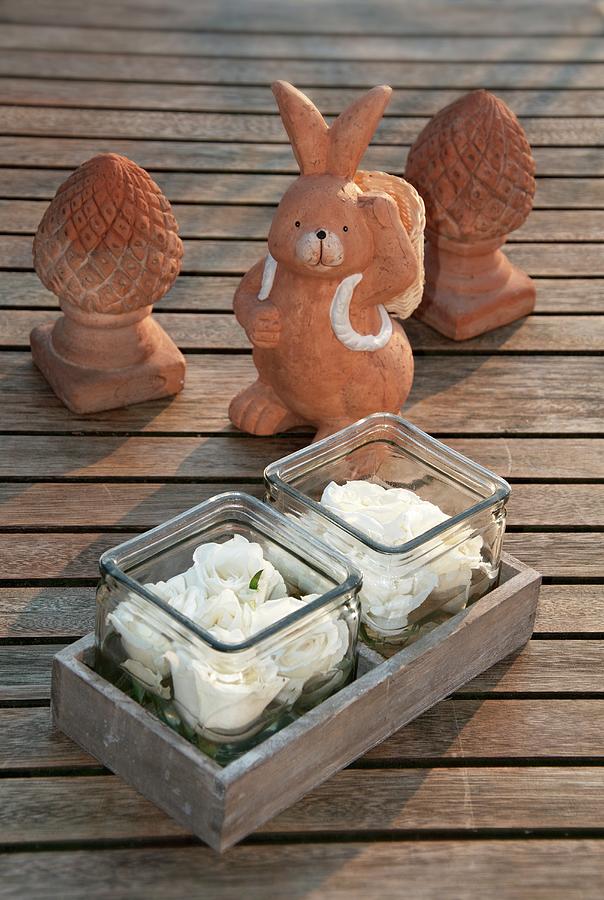 Roses In Glasses With A Clay Rabbit Figure On Wooden Boards Photograph by Chris Schfer