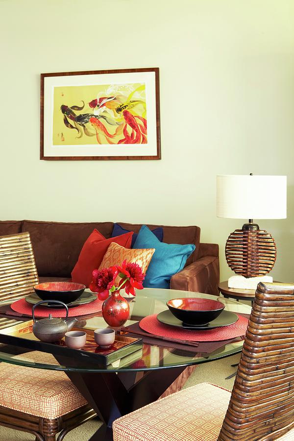 Round Glass Table With Two Oriental Place Settings And Comfortable Sofa Against Wall Below Modern Artwork Photograph by Anastassios Mentis Photography