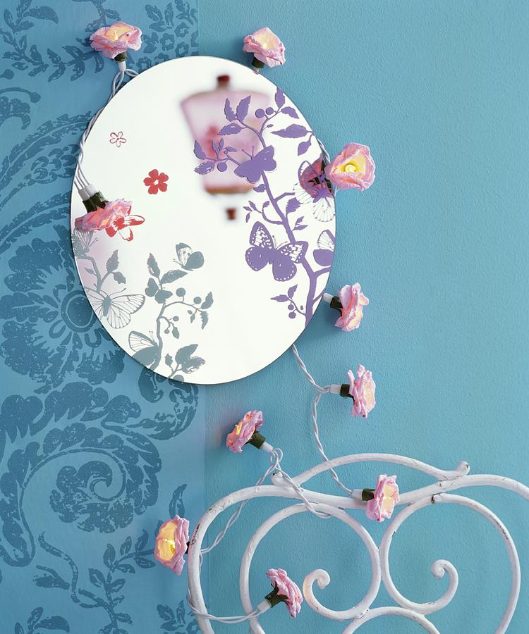 Round Mirror With Butterfly Motifs And Floral Fairy Lights On Blue Wall Photograph by Matteo Manduzio