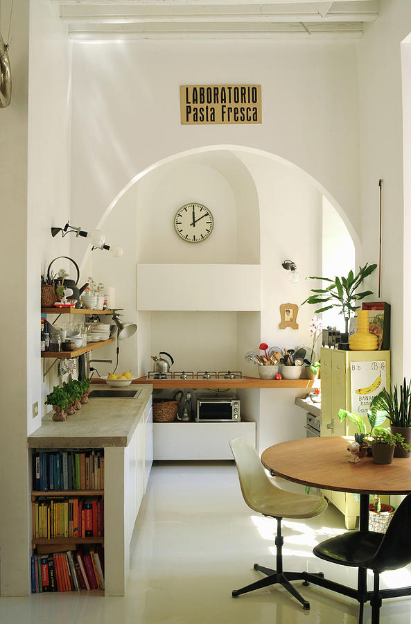Round Table, Classic Chairs, Kitchen Counter With Concrete Worksurface And Mobile Gas Cooker In Kitchen With Arched Doorway Photograph by Michele Mulas