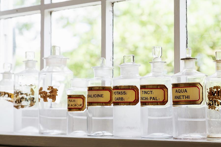 Row Of Apothecary Jars With Labels On Windowsill Photograph by Rikard Osterlund