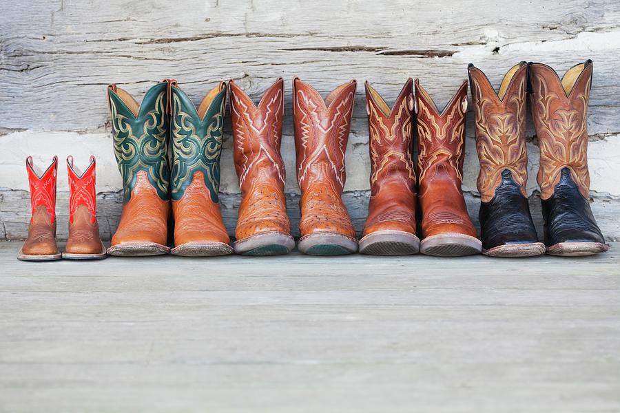 Row Of Cowboy Boot On Porch Of Log Cabin Photograph by Vstock Llc