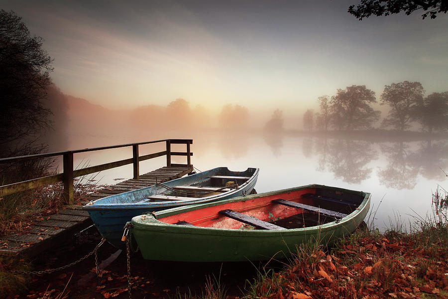 Rowing Boats Moored On Banks Of Wooded Photograph by Angus Clyne
