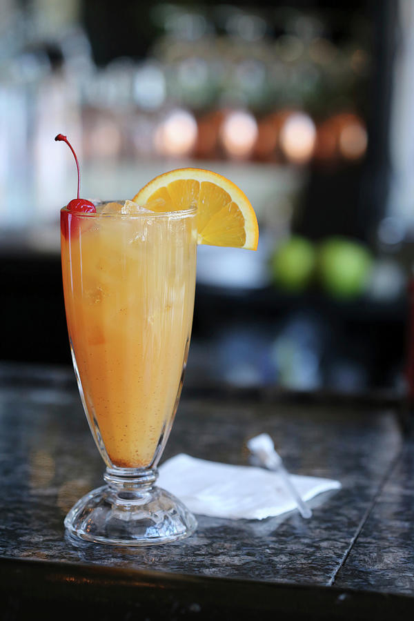 Rum Punch On A Bar With An Orange Slice And Marschino Cherry Garnish Photograph by Doug Schneider Photography