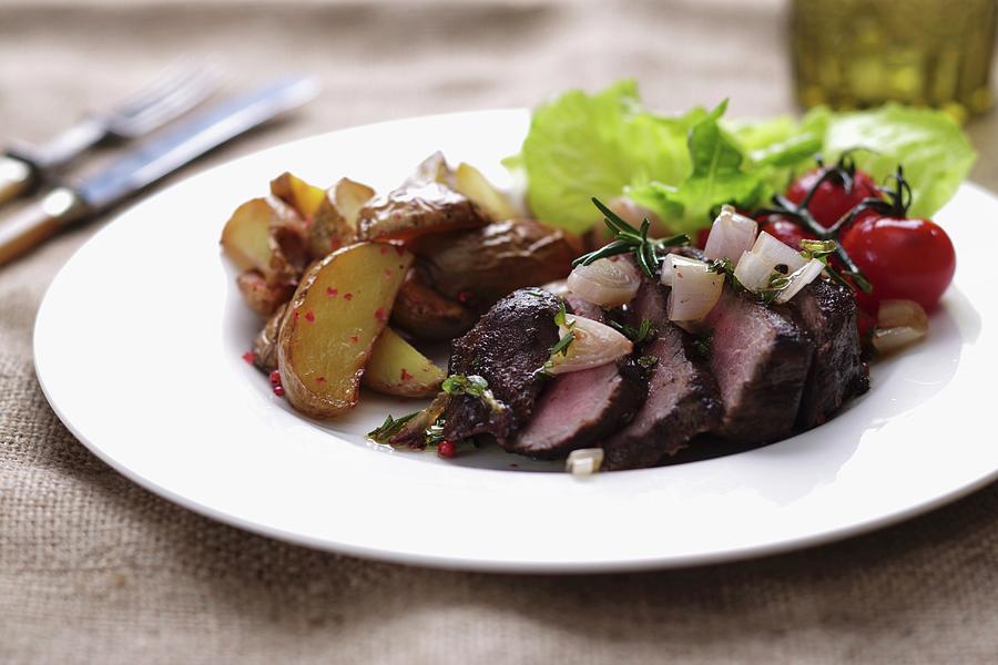 Rump Steak, Sliced, With Potato Wedges And Cherry Tomatoes Photograph by Frank Weymann