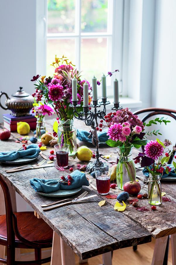 Rustic Arrangement Of Flowers And Fruit On Set Wooden Table Photograph by Carolin Strothe