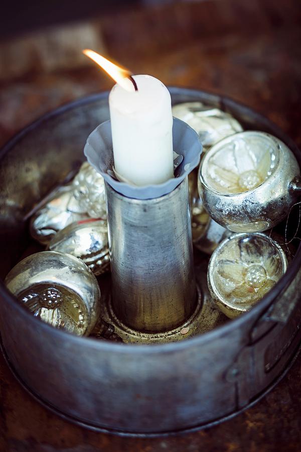 Rustic Christmas Arrangement Of Silver Baubles And Candle In Old Cake Tin Photograph by Eising Studio