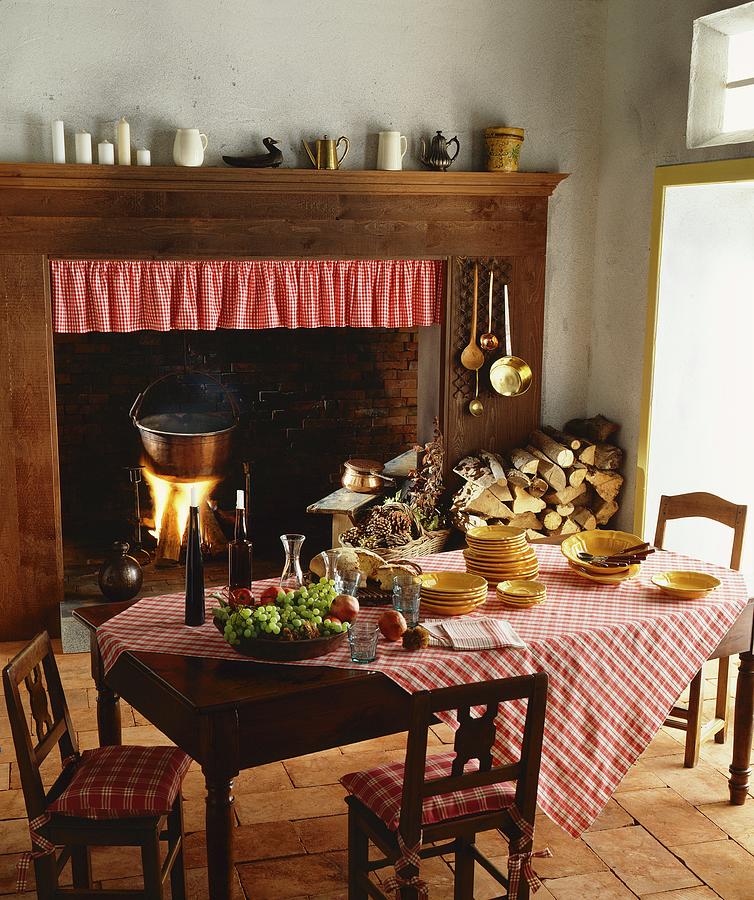 Rustic Hearth In Open Fireplace With Wooden Surround In Traditional Kitchen; Polenta Cooking In Pot Over Open Fire Photograph by Laura Rizzi