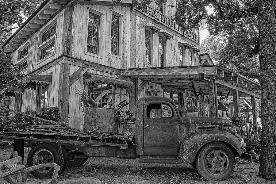 Black And White Photograph - Rusty Relic at Magnolia Pearl in Fredericksburg - Black and White by Lynn Bauer