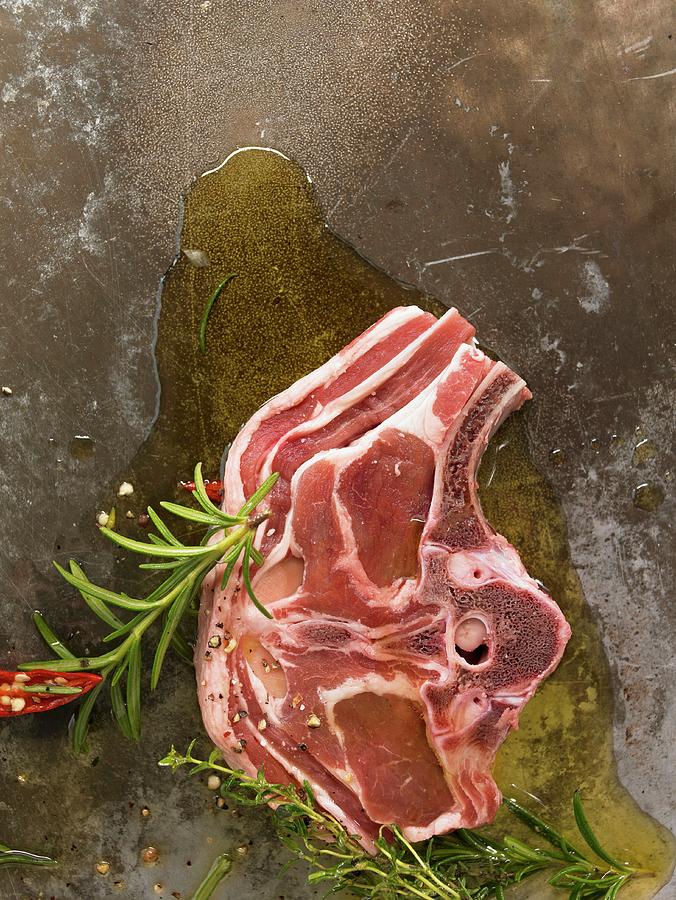 Saddle Of Lamb In Oil On A Metal Plate With Herbs And Spices Photograph by Hebra