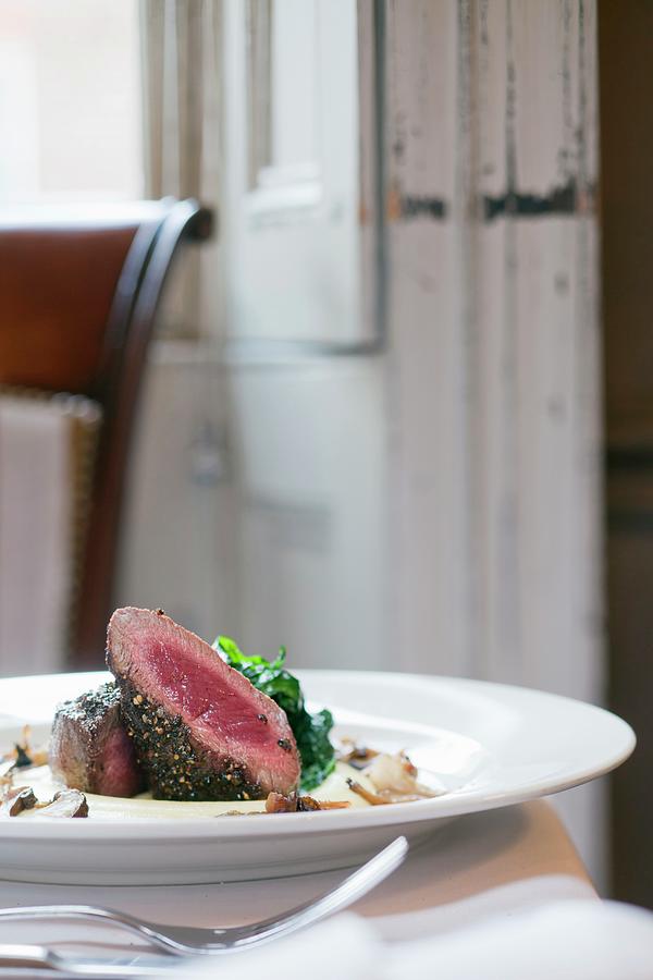 Saddle Of Venison With A Pepper Crust, Truffle Potatoes And Mushroom Sauce Photograph by Jalag / Markus Bassler