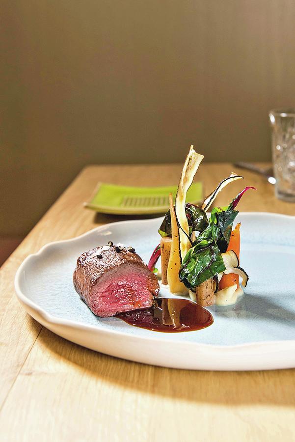 Saddle Of Venison With Black Salsify And Swiss Chard Served At The 1908 Restaurant At The Parkhotel Holzner In The Community Of Ritten, South Tyrol, Italy Photograph by Jalag / Michael Schinharl