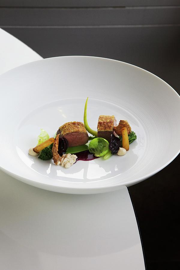 Saddle Of Venison With Winter Vegetables, Walnuts And Red Cabbage Juice Photograph by Jalag / Vera Hartmann