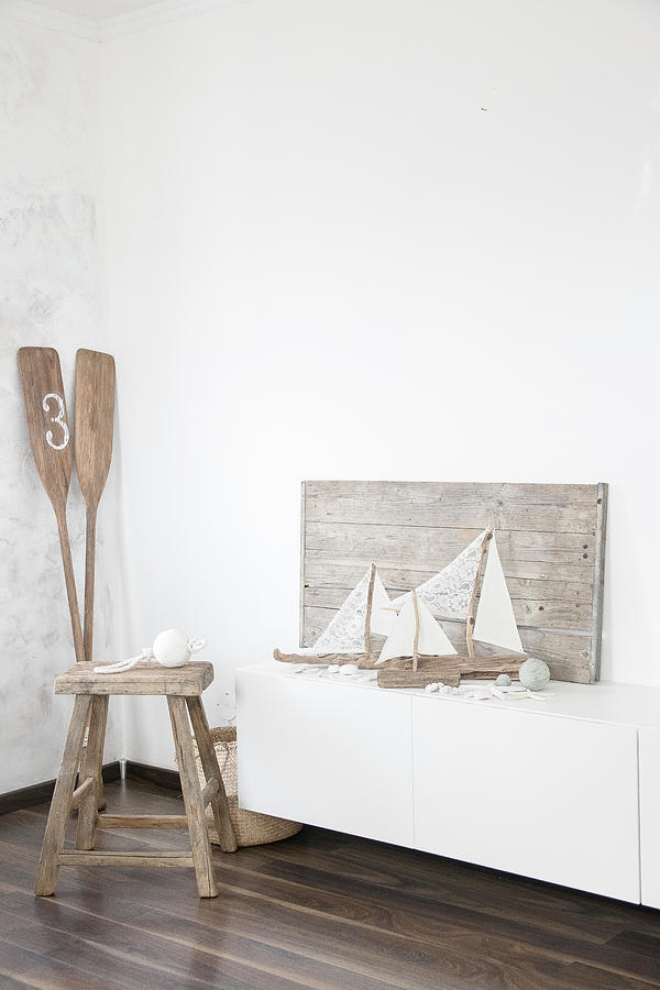 Sailing Boat Ornaments Made From Driftwood And Fabric Remnants Next To Stool And Paddles In Corner Photograph by Astrid Algermissen