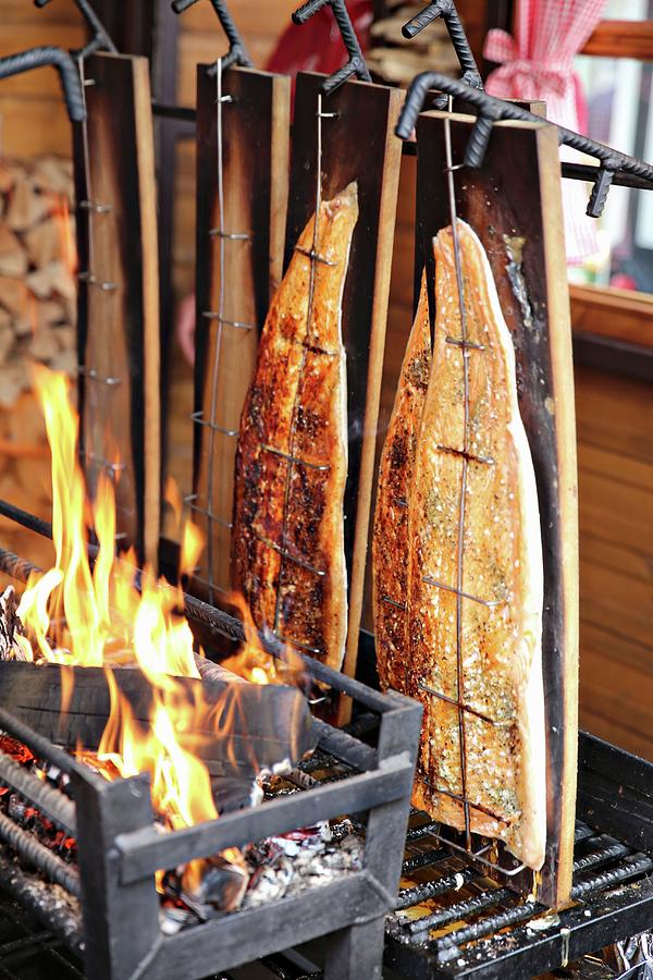 Salmon Being Grilled Over An Open Fire Photograph by Alexandra Panella