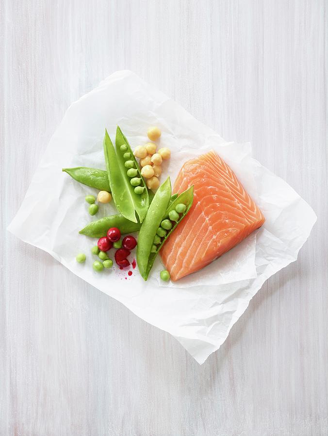 Salmon Fillet With Peas, Chickpeas And Cranberries On A Piece Of Paper Photograph by Leigh Beisch