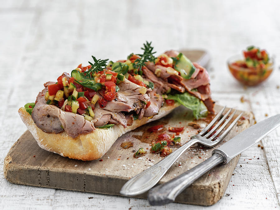 Sandwich Rolls With Roast Beef And Bell Pepper-zucchini Salsa On A Wooden Board Photograph by M. Nlke