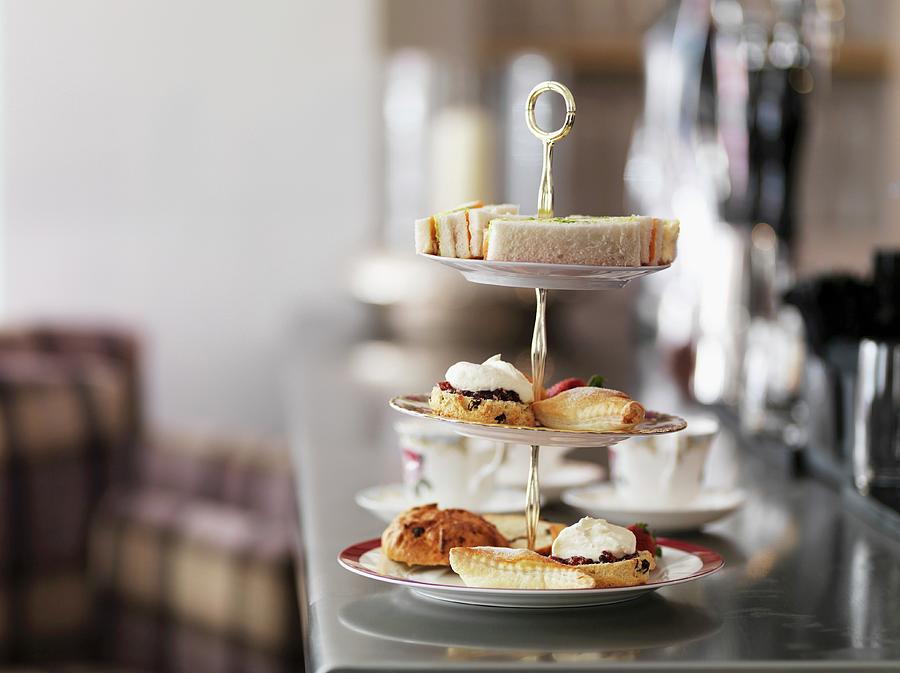 Sandwiches, Cakes And Pastries On A Cake Stand For Afternoon Tea Photograph by Rob Whitrow