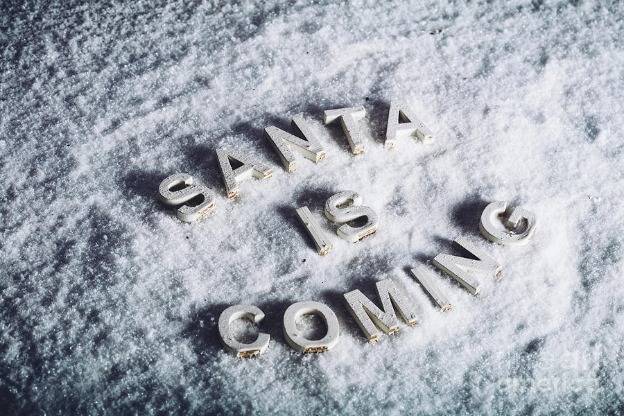SANTA IS COMING writing on white snowy background. Photograph by Michal Bednarek