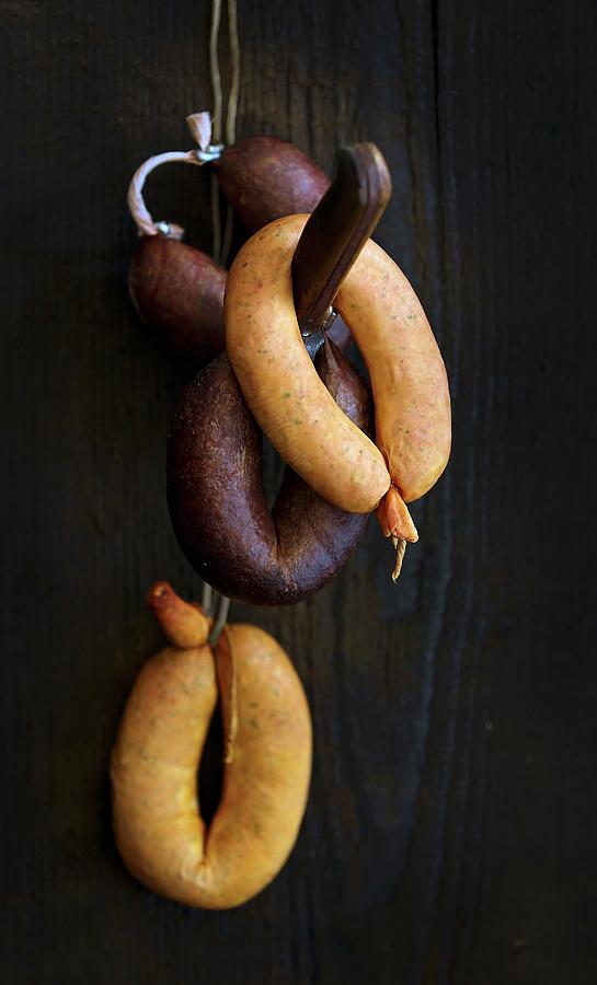 Sausages On A Hook Against A Wooden Wall Photograph by Jalag / Michael Bernhardi