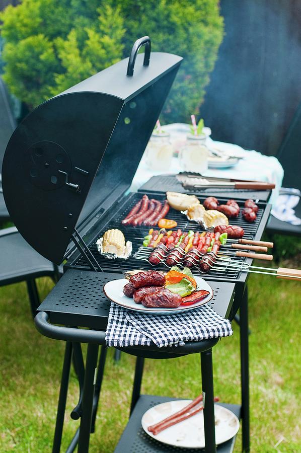 Sausages, Skewers And Vegetables On A Charcoal Barbecue Photograph by Tomasz Jakusz