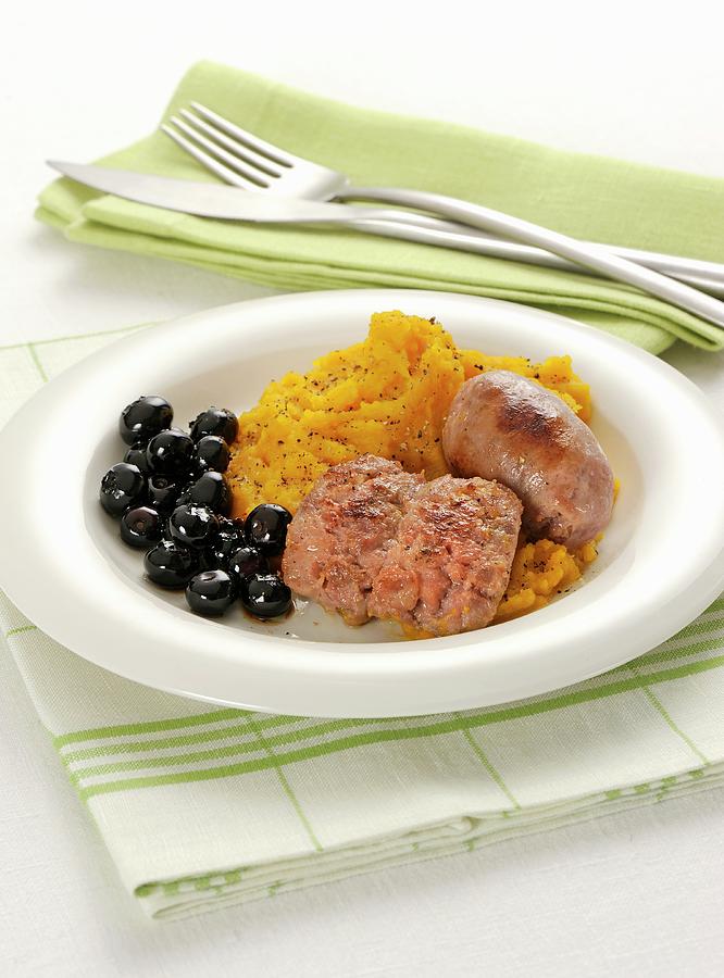 Sausages With Mashed Pumpkin And Black Olives Photograph by Franco Pizzochero