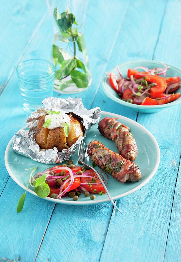 Sausages Wrapped In Parma Ham With Sage Served With A Tomato Salad And A Baked Potato Photograph by Peter Kooijman