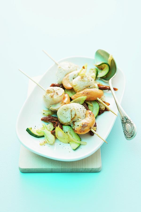 Scallop Skewers On A Bed Of Courgette And Dried Tomatoes Photograph by Michael Wissing
