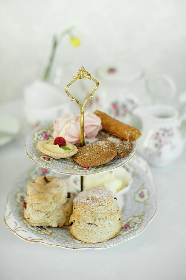 Scones And Petit Fours On A Cake Stand For Afternoon Tea Photograph by Magdalena Hendey