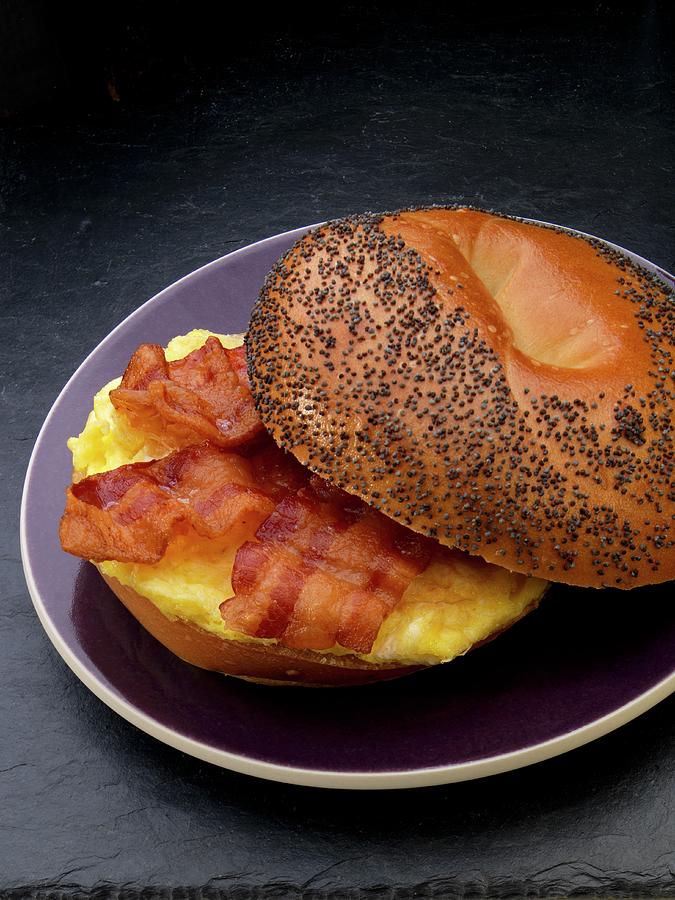Scrambled Egg And Bacon On A Poppy Seed Roll For Breakfast Photograph by Paul Poplis