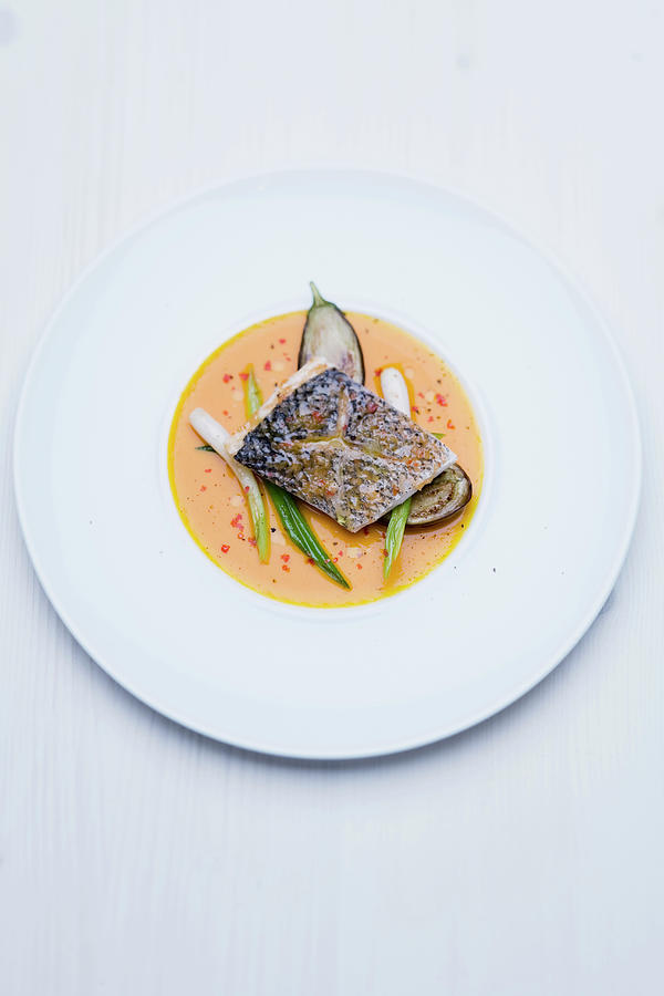 Sea Bass Fillet With Lemon Grass And Ginger Flowers, Roasted Aubergines And Spicy Pumpkin Sauce Photograph by Michael Wissing