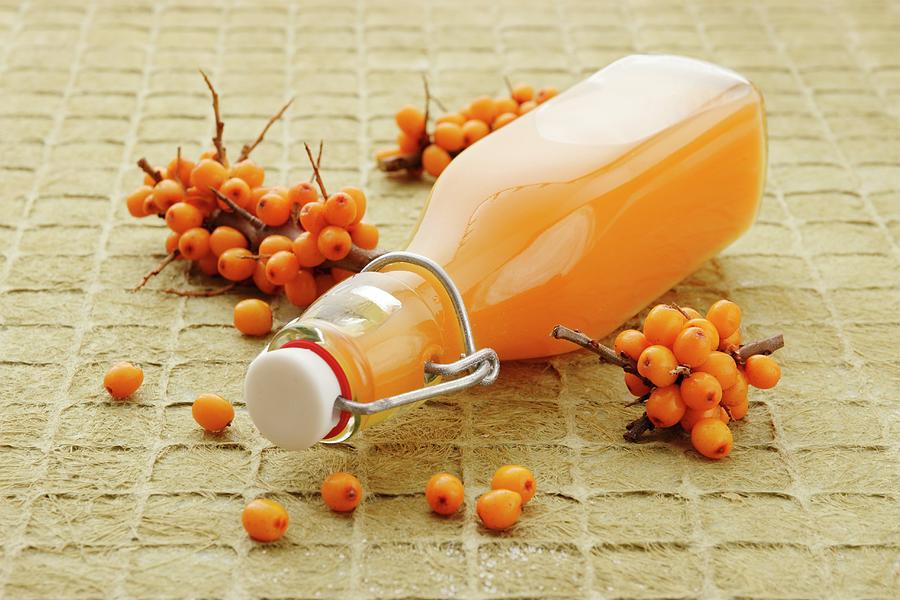 Sea Buckthorn Juice In A Stoppered Bottle Photograph by Petr Gross