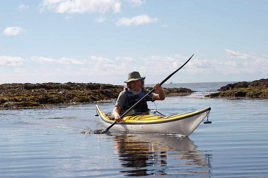 Sea Kayaker Paddling Canoe On Coastal Photograph by Andrew Holt
