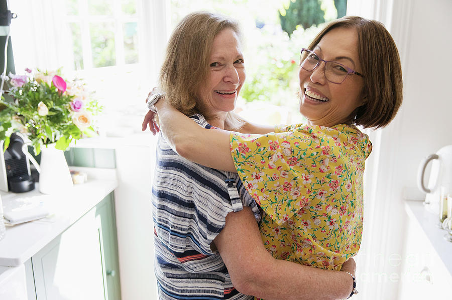 Senior Lesbian Couple Hugging In Kitchen Photograph By Caia Imagescience Photo Library 