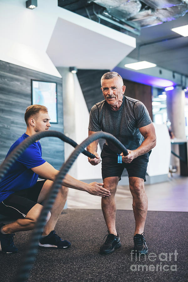 Senior man exercising with ropes at the gym. Photograph by Michal Bednarek