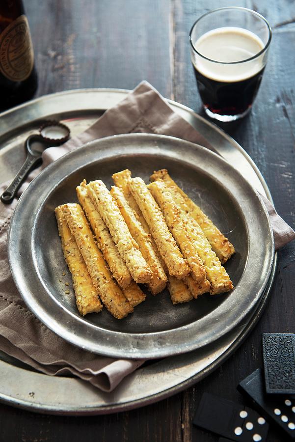 Sesame Breadsticks And Beer Photograph by Veronika Studer