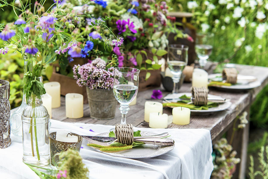 Set Table Decorated With Wildflowers And Candles In Garden Photograph by Bildhbsch