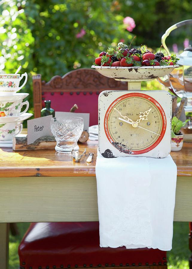 Set Table In Sunny Garden; Bowl Of Fresh Berries On A Kitchen Scale Converted Into A Clock Photograph by Great Stock!