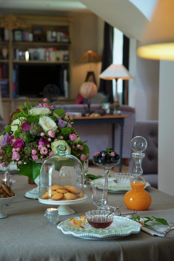 Set Table With Pastries Under Glass Cover, Vase Of Flowers And Glass Carafe Of Juice Photograph by Christophe Madamour